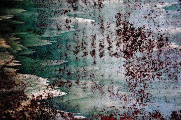 Rusty metal surface painted with paint and cracked from time to time