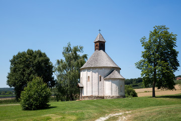 Fototapeta na wymiar Old round church on the grass field