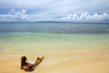 Fototapeta na wymiar Young woman in bikini lying on the beach on Taveuni Island, Fiji