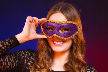 Closeup woman face with carnival violet mask on dark