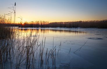 Winter landscape with sunset sky and frozen river. Daybreak