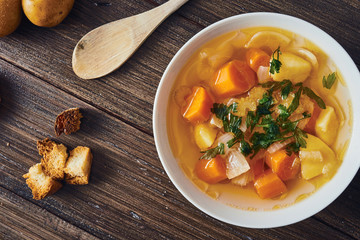 Vegetable soup in white bowl on wooden table