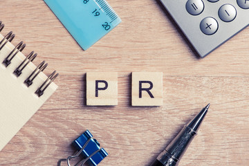 PR abbreviation on table spelled with education game elements - obrazy, fototapety, plakaty