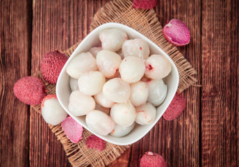 Portion of Lichee Fruits on wooden background (selective focus)