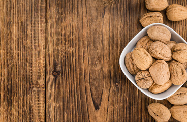 Portion of Whole Walnuts on wooden background (selective focus)