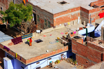 Local woman walking on a flat roof of the house in Jaipur, Rajas