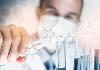 Portrait of concentrated male scientist working with reagents in laboratory