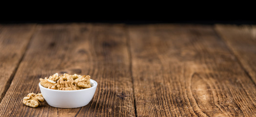 Portion of Cracked Walnuts on wooden background (selective focus