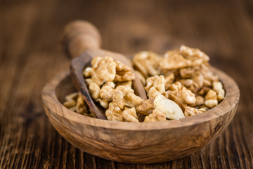 Portion of Cracked Walnuts on wooden background (selective focus