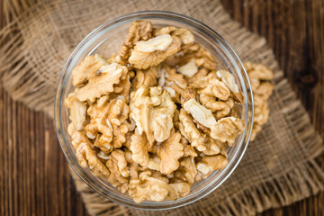 Portion of Cracked Walnuts on wooden background (selective focus