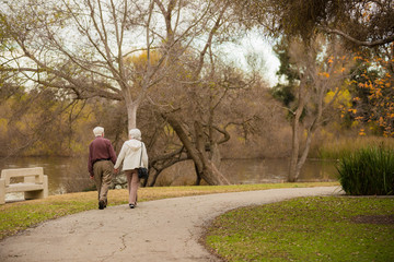 Senior citizens walking in a park with lake fall colors