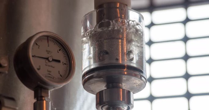 Microbrewery equipment 4k close-up video. Gauges pressure control device: manometer at craft brewery. Water gurgles and water bubbles.