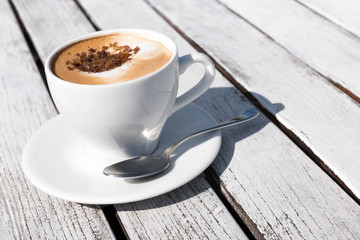 Tasse Cappuccino auf weißem Holztisch, Kaffeepause, italienisch, Spezialitäten, Heißgetränke