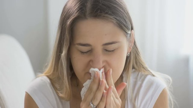 Closeup shot of sick woman sneezing in handkerchief