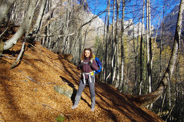 Young attractive female hiker in a forest path in the Dolomites.