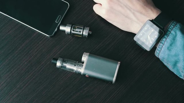 businessman with an e-cigarette on the stylish table