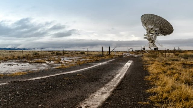 Road to Radio Telescope. Time-lapse looking down a muddy road at a telescope dish at the Karl G. Jansky Very Large Array (VLA) near Socorro, New Mexico.
