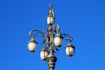 Fototapeta na wymiar Street lamp on Piazza Unita d'Italia against blue sky, Trieste,