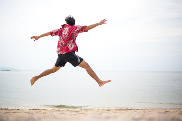 Fototapeta premium Athletic young man enjoying the summer, jumping in a tropical beach.