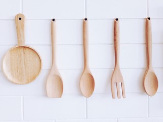 Close up of wooden plate and utensils hanging on the wall, vintage style