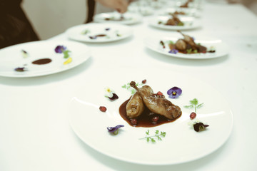 chef using chopsticks tong sliced beef put on the white plate in