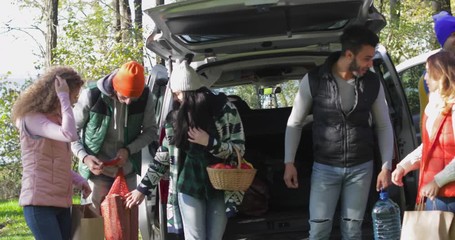 Young People Group Arrive At Picnic Place Unpacking Car In Autumn Park, Friends Forest Carry Bags Slow Motion 60