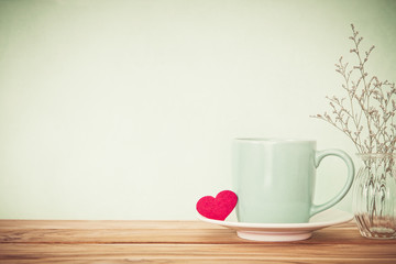 Coffee cup mug with red heart shape on wooden table , Romance 