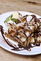 Close up of vanilla ice cream with waffle on wood table backgrou