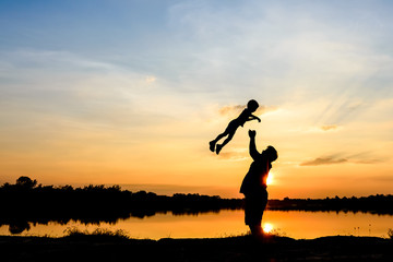 silhouette of father and son at sunset