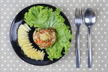 Fried brown rice with pineapple in yellow curry powder.