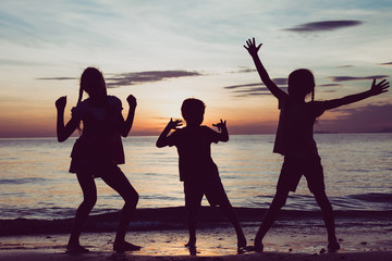 Fototapeta premium Happy children playing on the beach at the sunset time.