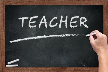 Teacher word chalkboard with hand hold chalk on wooden board dirty with chalk stain empty space for...