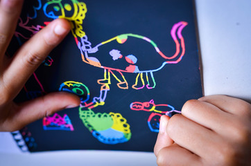 Happy boy draws  on a Scratch note colorful