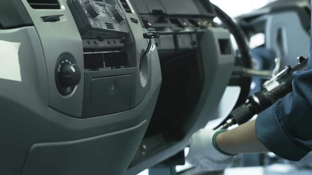 The assembling of a car dashboard on the conveyor