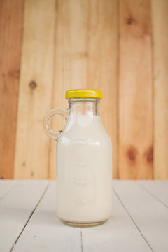 Bottle glass of Milk on a wooden table.