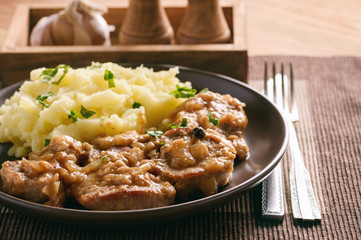 Pork tenderloin cooked in onion sauce served with mashed potatoes.