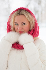 Winter portrait of beautiful woman in pink scarf and white coat. Blonde lady with green eyes.