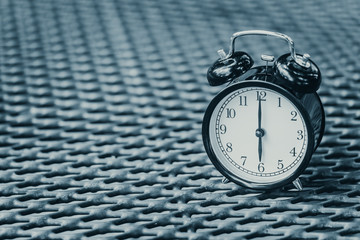 retro clock at 6 o'clock on steel factory style table vintage color tone with copy space