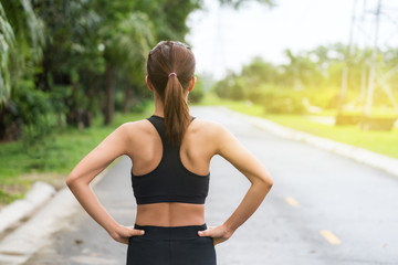 Back view of young fitness woman running on the road in the morning, People and sport concept, Selective focus
