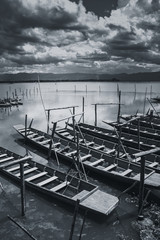 quiet shore in rural with wooden fishing boat in countryside lake sky and cloud black and white tone.