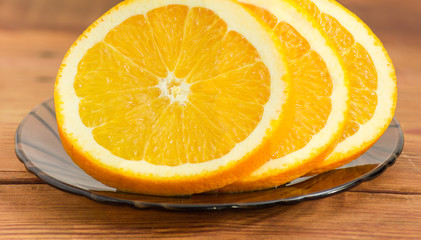 Slices of an orange on a glass saucer closeup