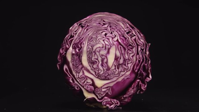 Cutting of purple cabbage on a black backgroung (stop-motion)