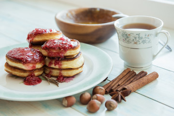 Pancakes, jam, honey, cinnamon, and a Cup of coffee on the table