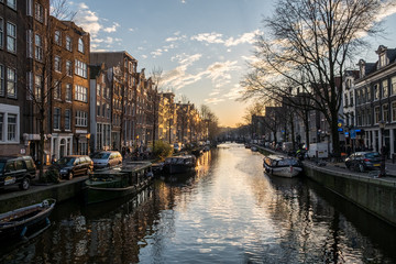 Fototapeta na wymiar Beautiful sunset over Amsterdam, The Netherlands, with water canals and crazy architecture