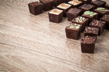 Delicious chocolate candies on the wooden background.