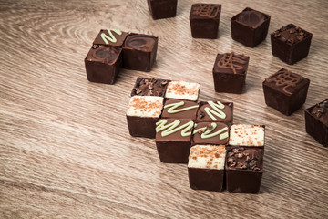 Delicious chocolate candies on the wooden background.