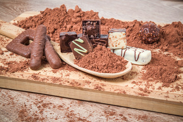 Delicious chocolate candies on the wooden background.