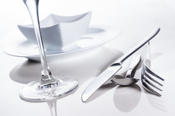 Besteck und Geschirr auf spiegelndem Untergrund, Hintergrund