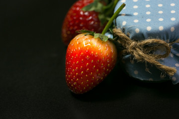 strawberry and blue honey button on black background