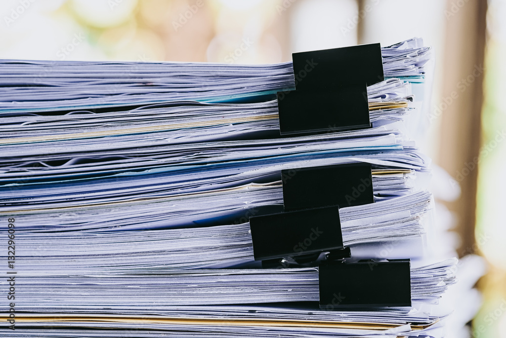 Poster stack of business report paper file on modern white office desk with bokeh background.